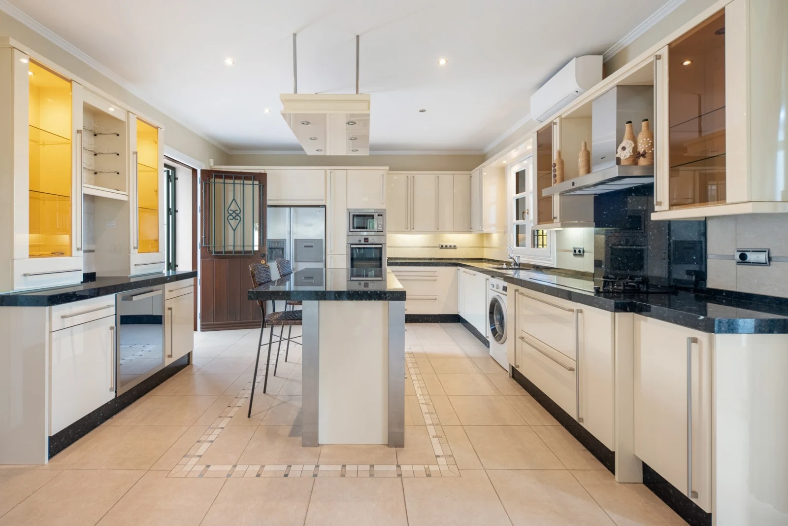 Fitted kitchen with island and built-in appliances