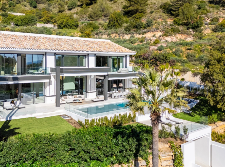 Villa exterior with landscaped gardens and pool in daylight