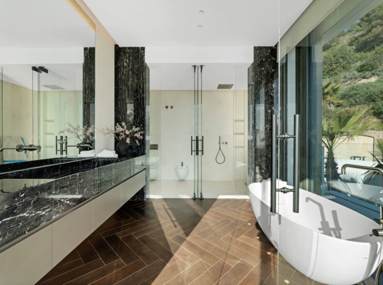 Bathroom with freestanding bathtub and garden-facing windows