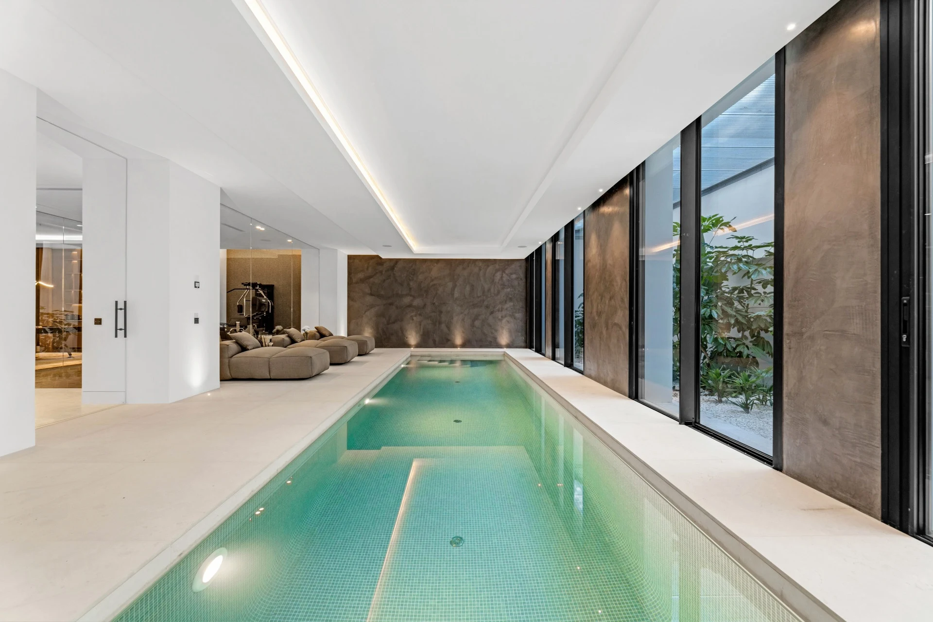 Heated indoor swimming pool beside a glazed courtyard