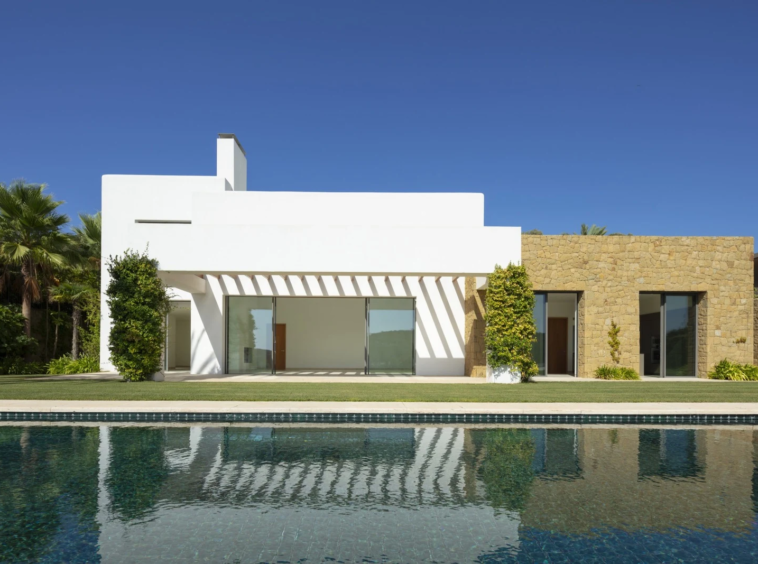Pool-facing facade with white walls and natural stone