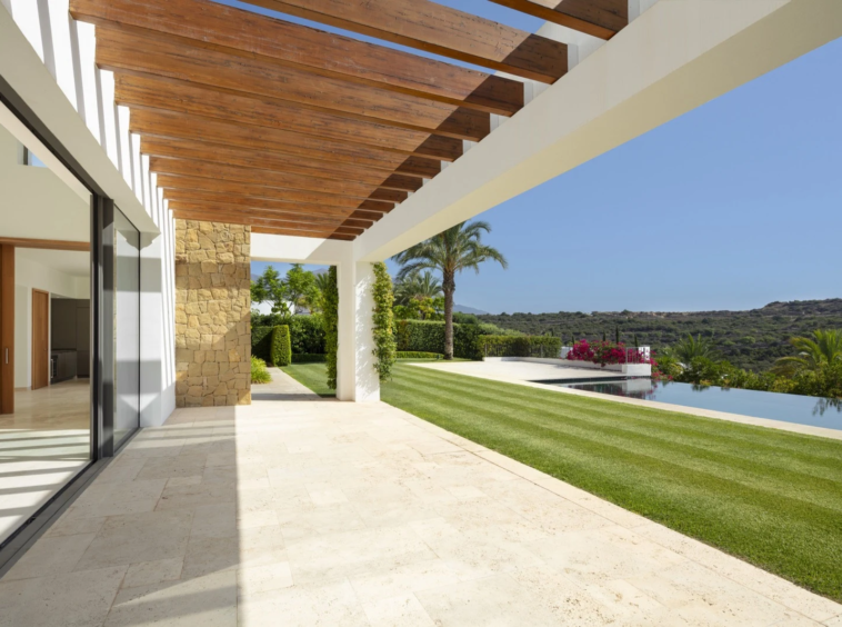 Covered terrace opening onto the lawn and pool