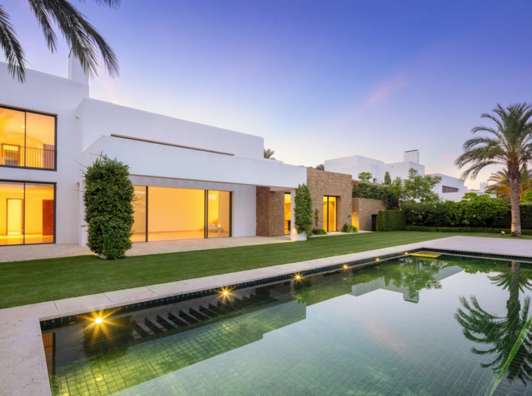 Villa and swimming pool illuminated at dusk