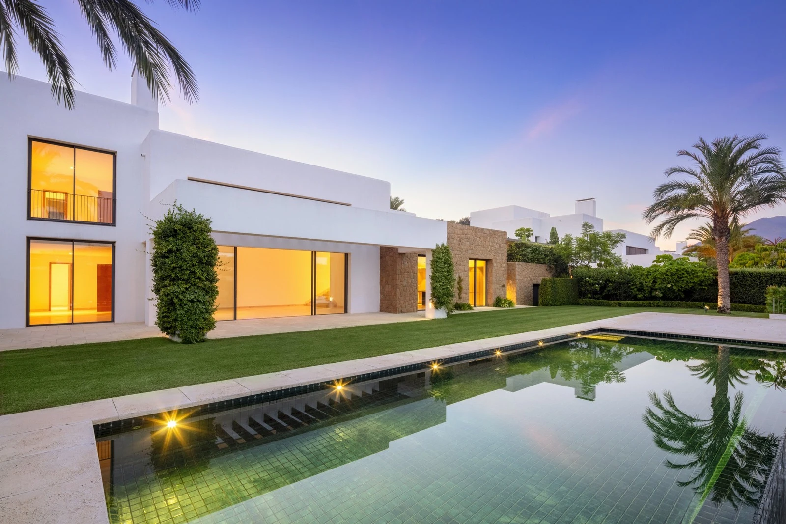 Villa and swimming pool illuminated at dusk
