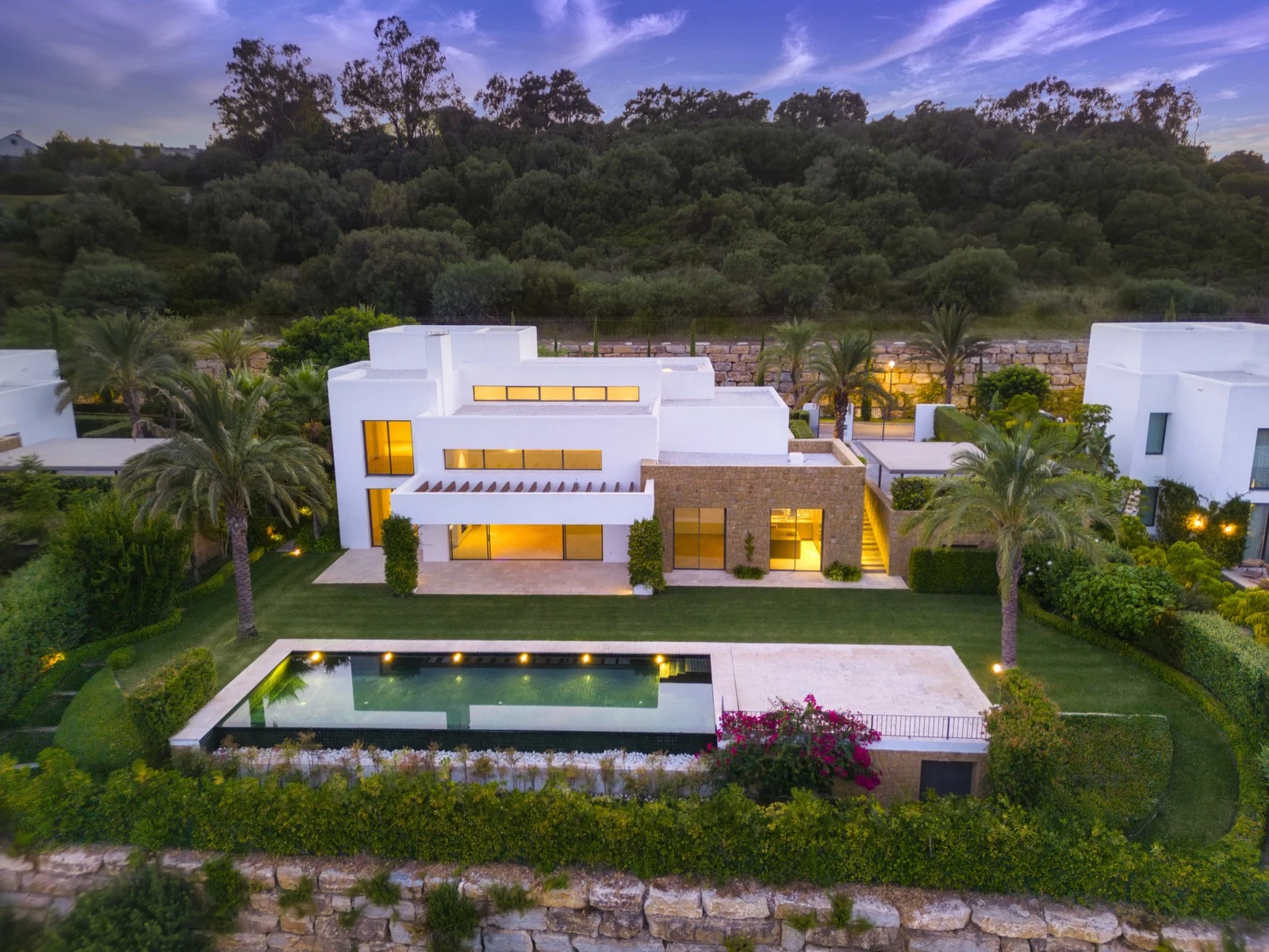 Elevated twilight view of the villa and garden