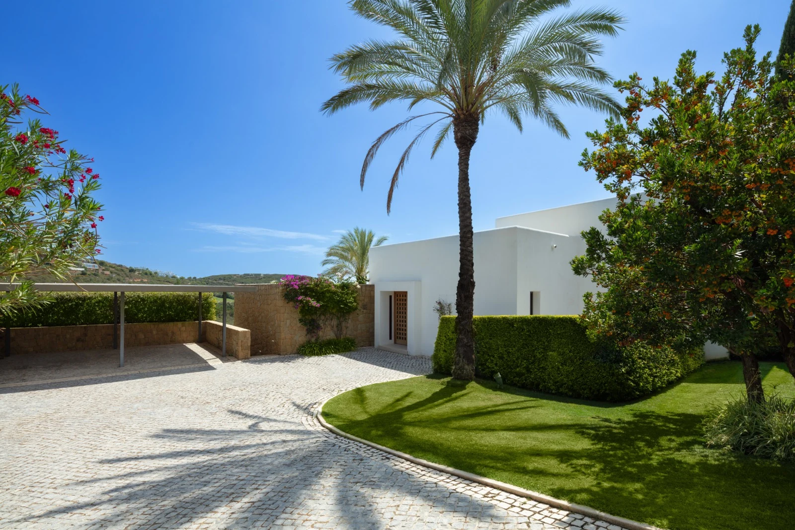 Private driveway and covered entrance beside mature palms