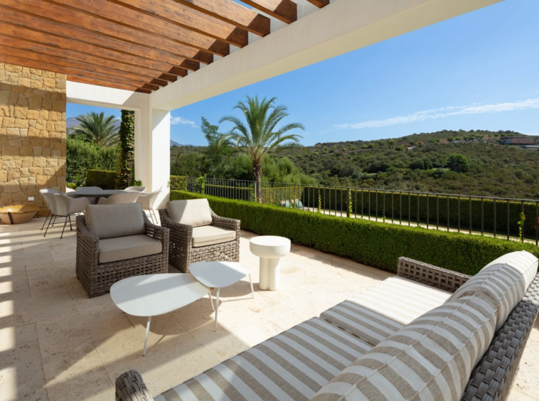 Shaded terrace with outdoor seating and golf views