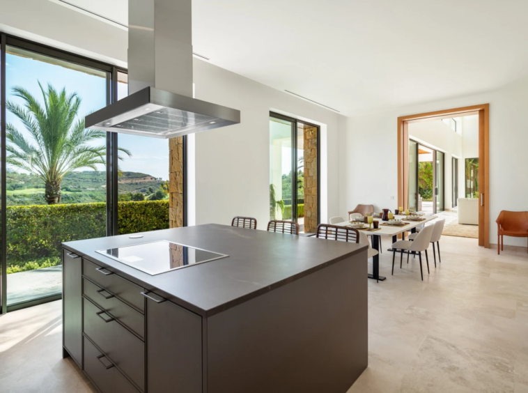 Kitchen island beside large garden-facing windows