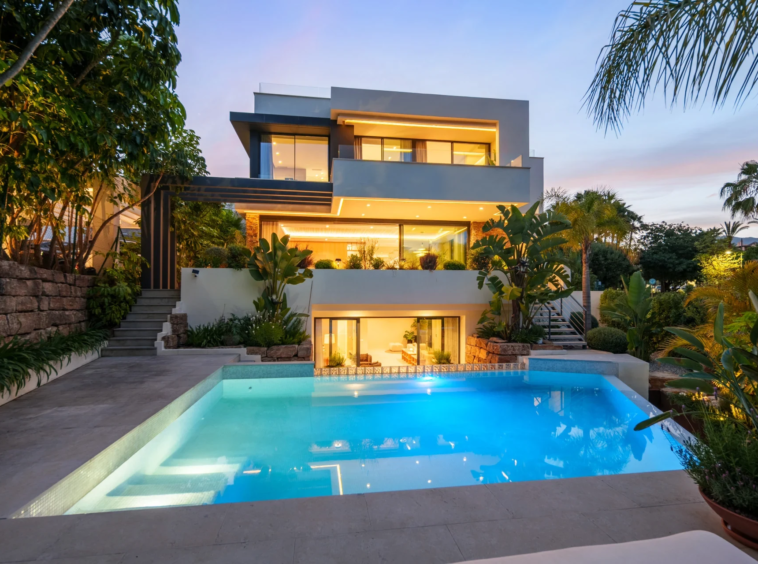 Villa and illuminated swimming pool at dusk