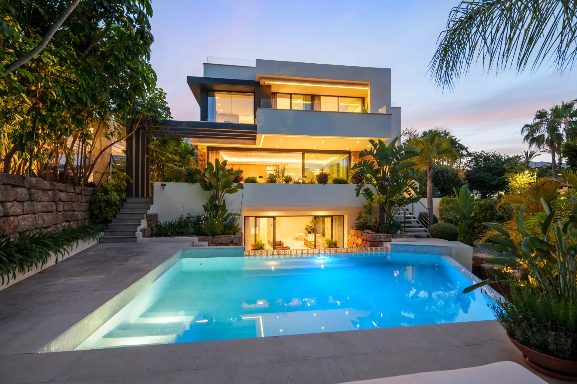Villa and illuminated swimming pool at dusk