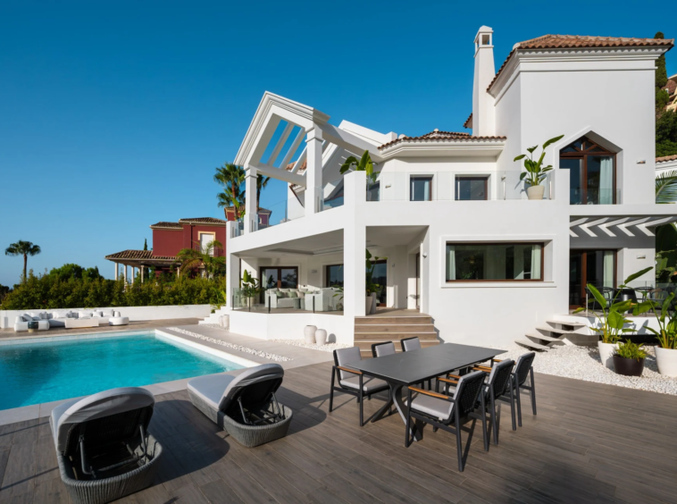 Private infinity pool beside the white villa facade