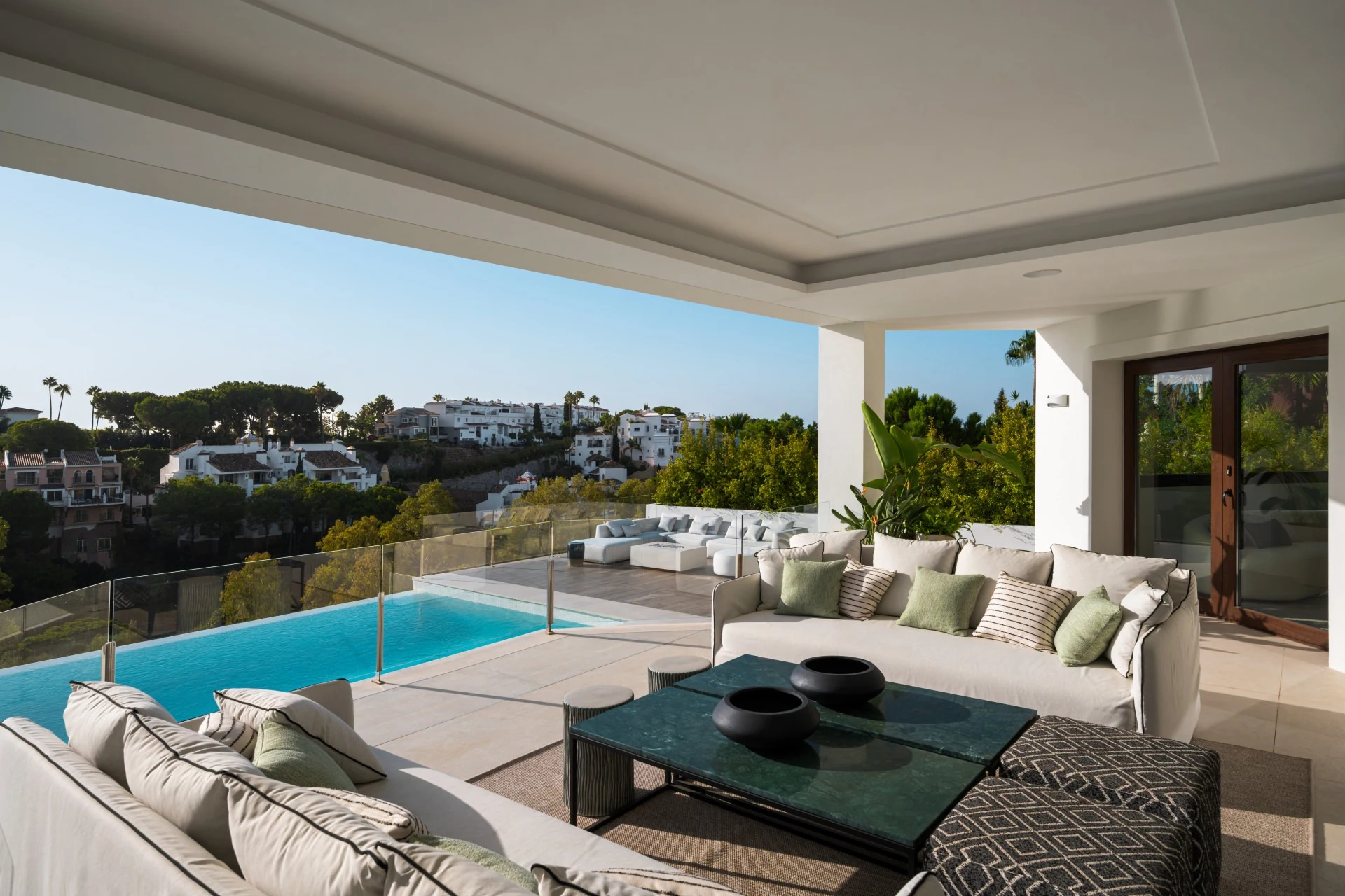 Covered lounge terrace overlooking the pool and neighbourhood