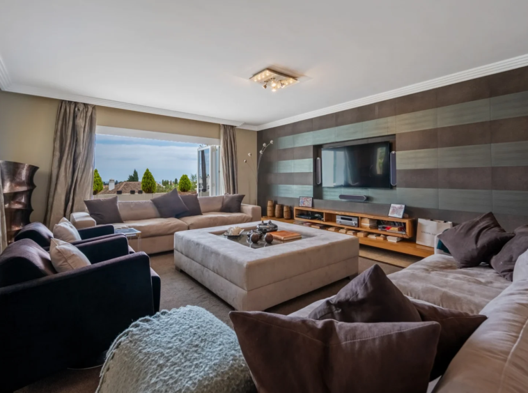 Living room with large windows and neutral furnishings
