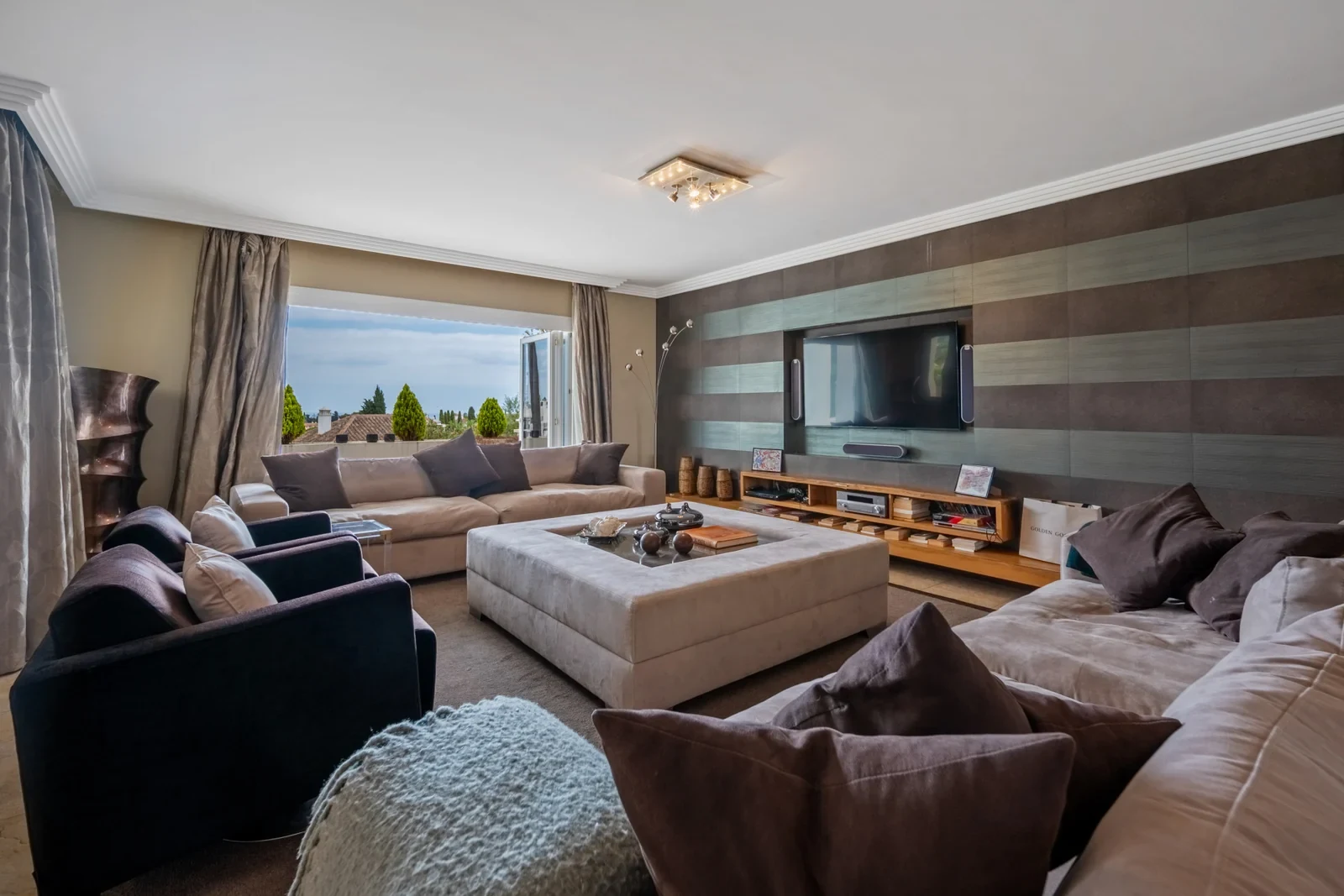 Living room with large windows and neutral furnishings