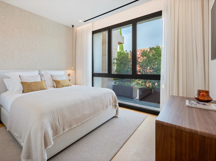 Bedroom with full-height windows and fitted storage