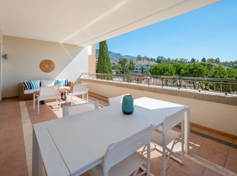Outdoor dining space overlooking gardens and the sea