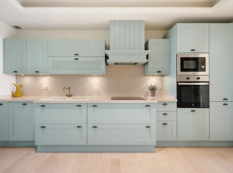 Fully fitted kitchen in pale green tones