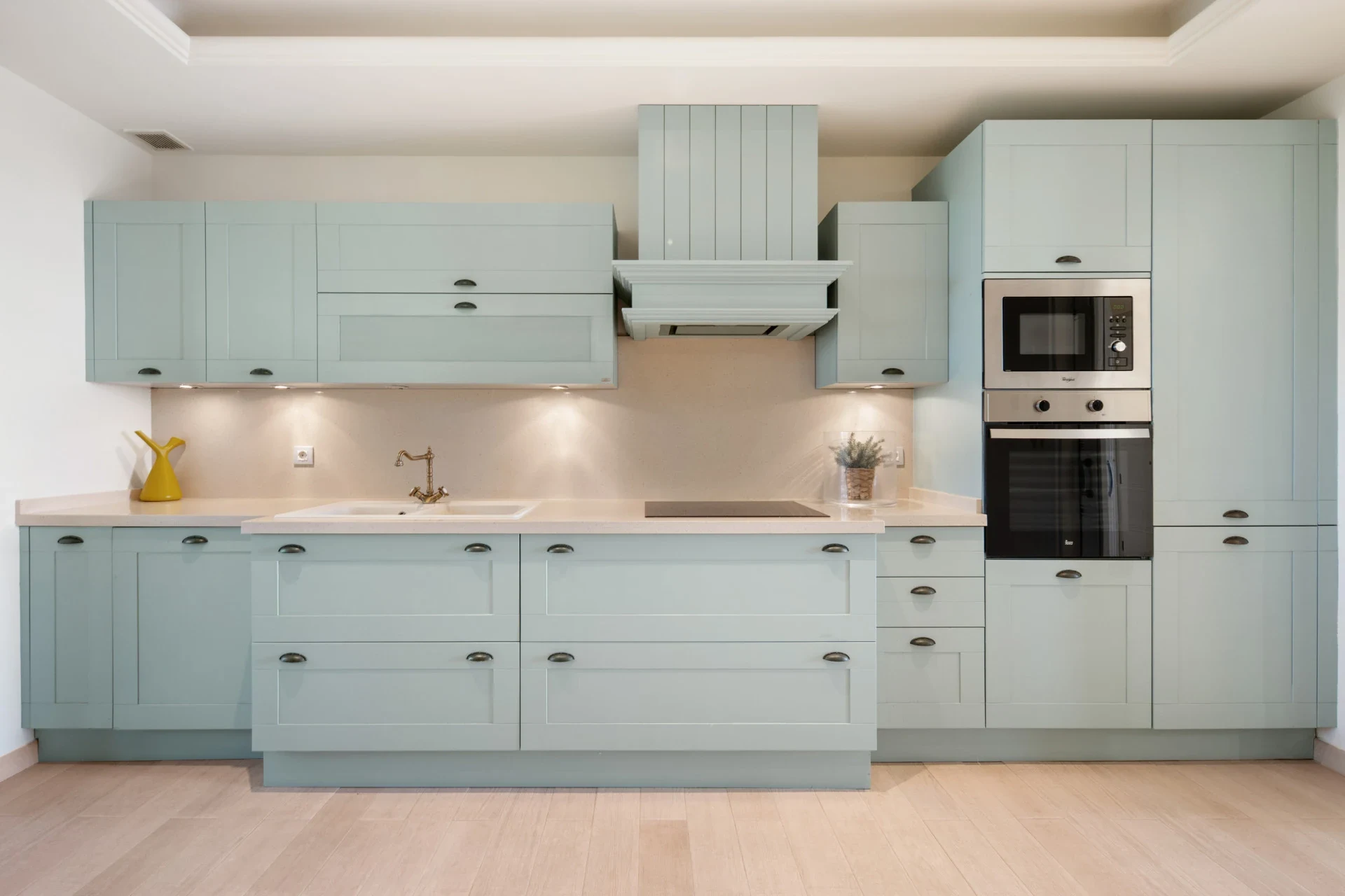 Fully fitted kitchen in pale green tones
