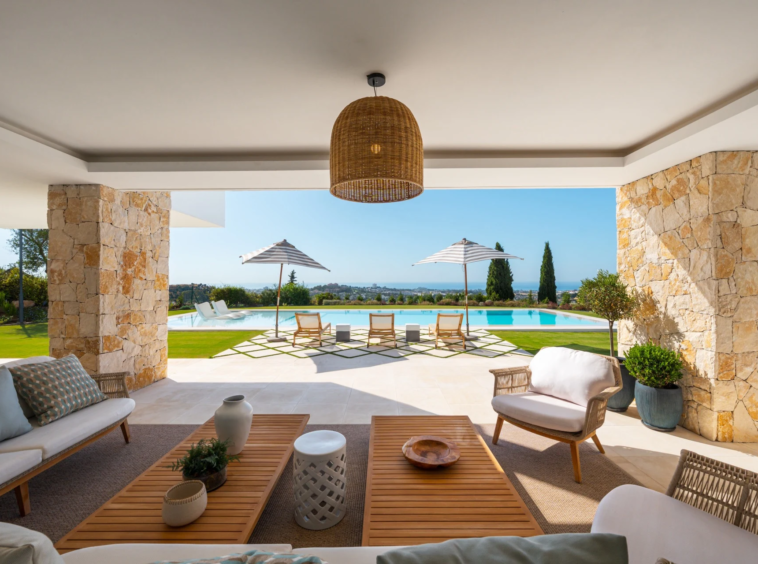 Covered outdoor lounge overlooking the pool and sea