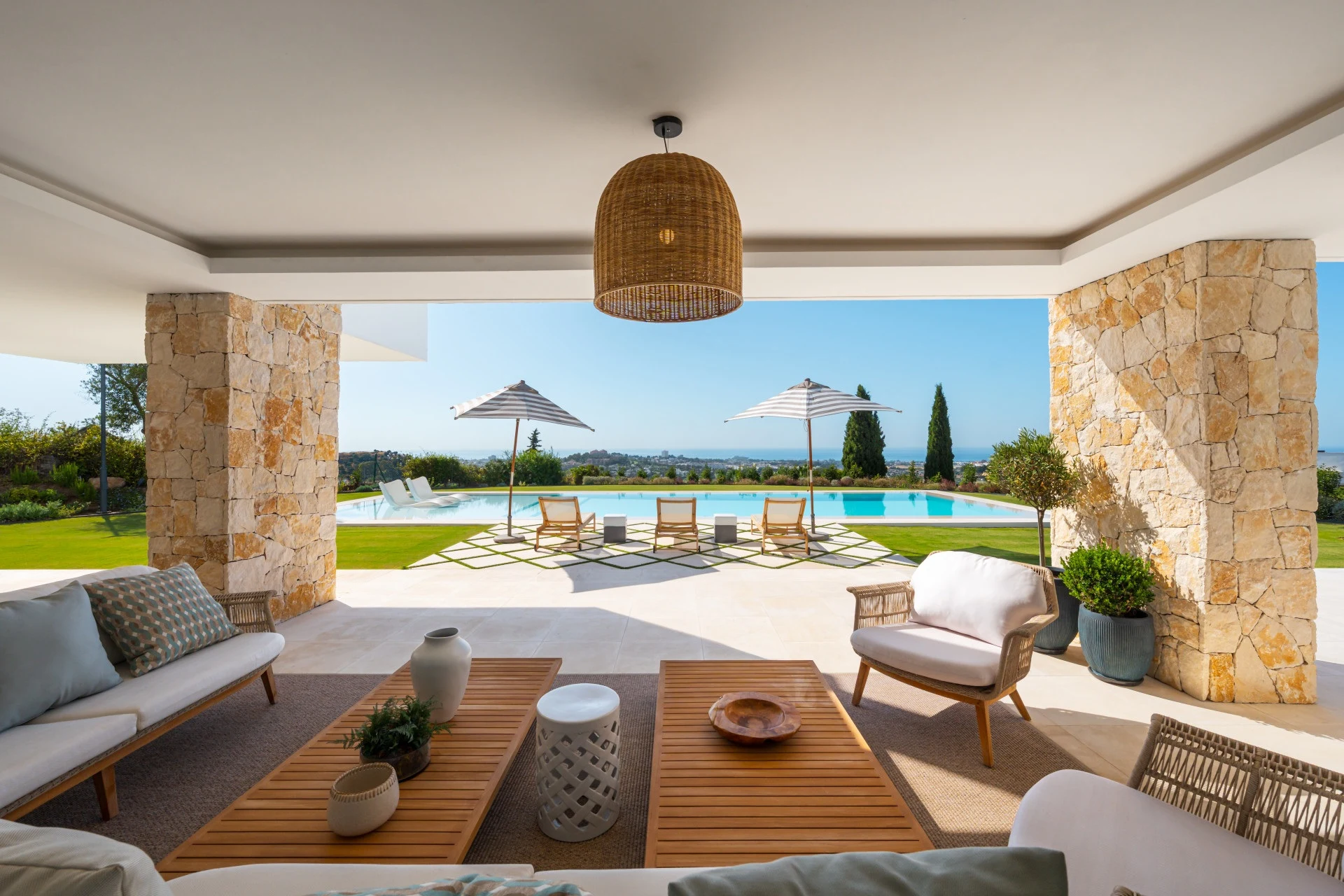 Covered outdoor lounge overlooking the pool and sea
