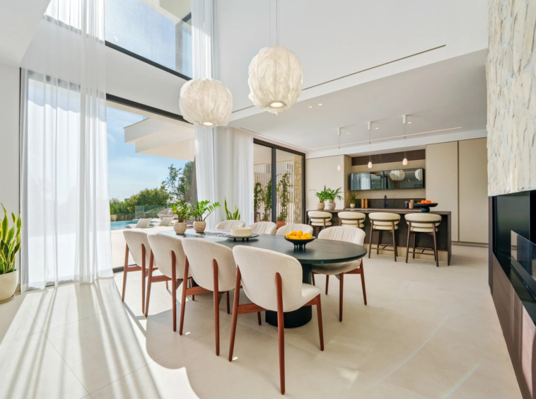 Open-plan dining area beside full-height windows