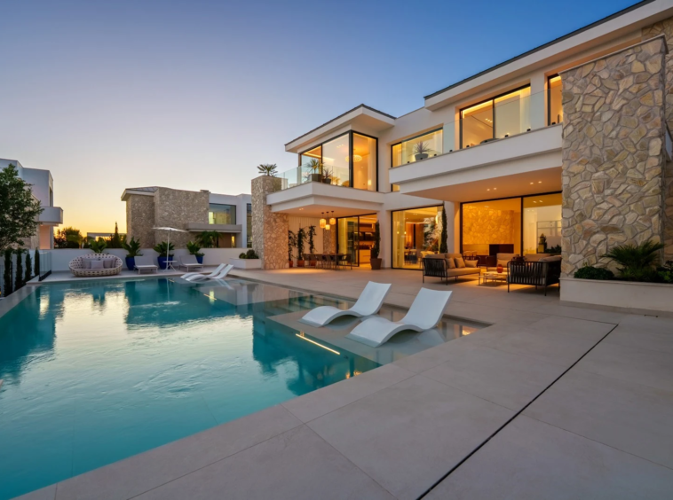 Villa and illuminated infinity pool at dusk