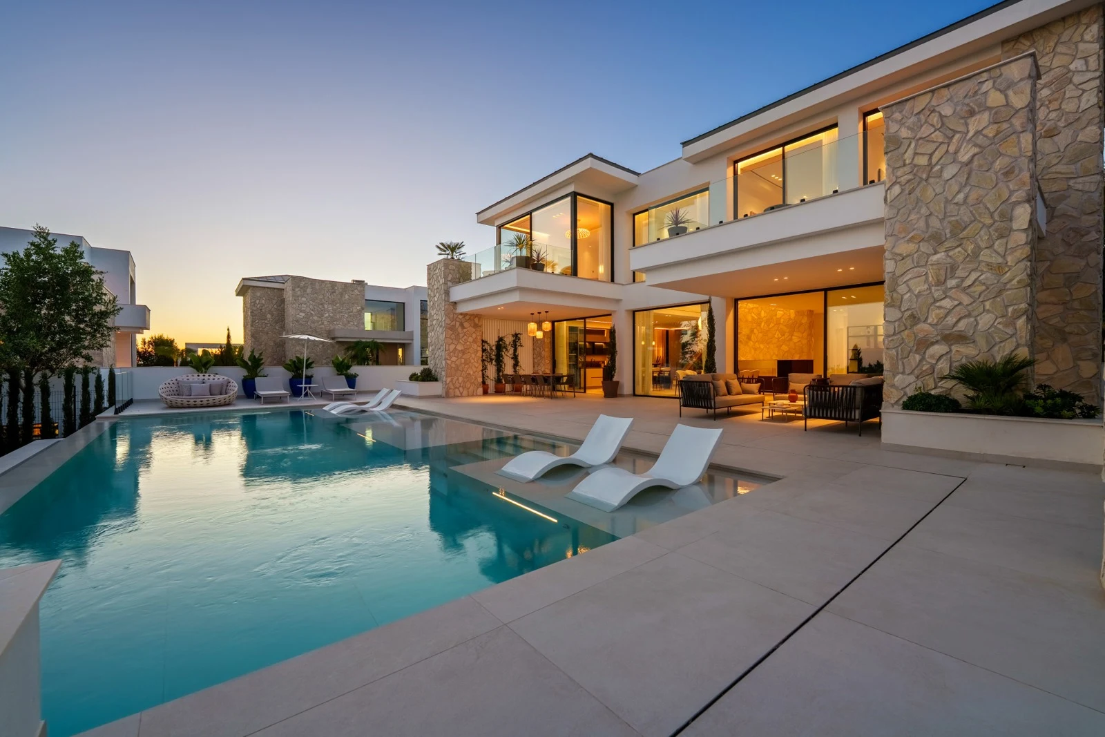 Villa and illuminated infinity pool at dusk