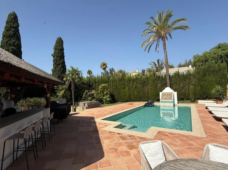 Swimming pool beside a covered outdoor area