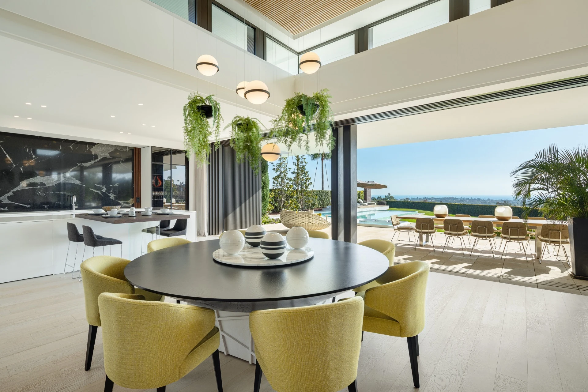 Dining area opening onto a terrace with sea views