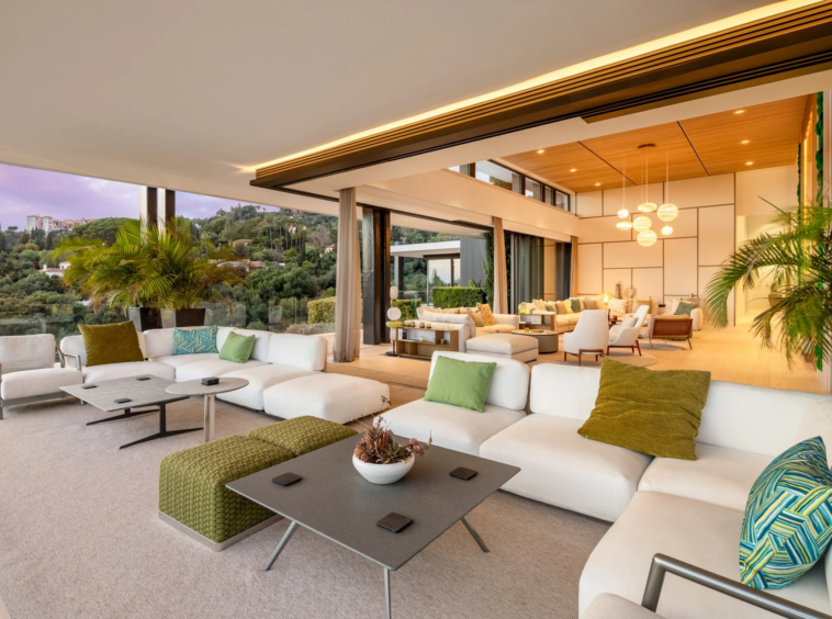 Outdoor lounge beside the illuminated villa at dusk