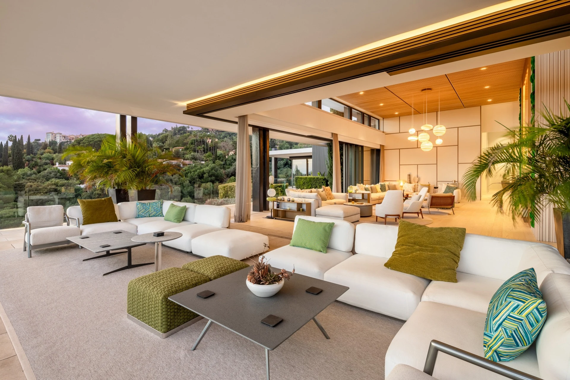 Outdoor lounge beside the illuminated villa at dusk
