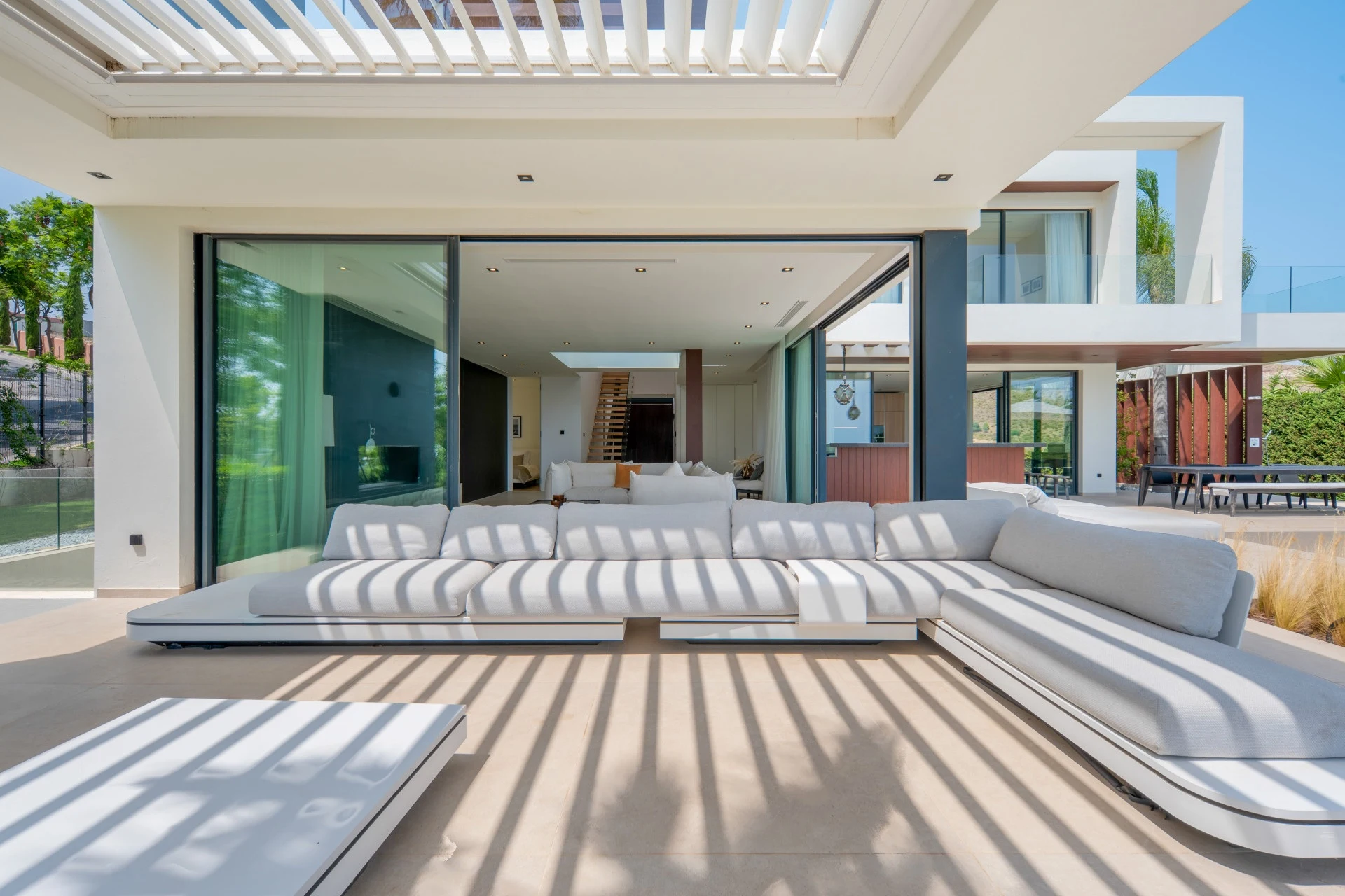 Covered terrace lounge beneath a slatted pergola