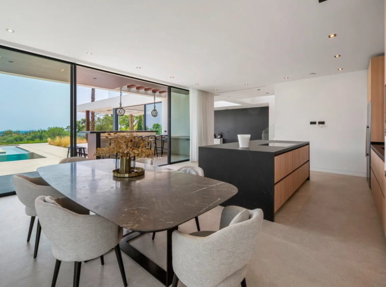 Dining area and open-plan kitchen overlooking the pool