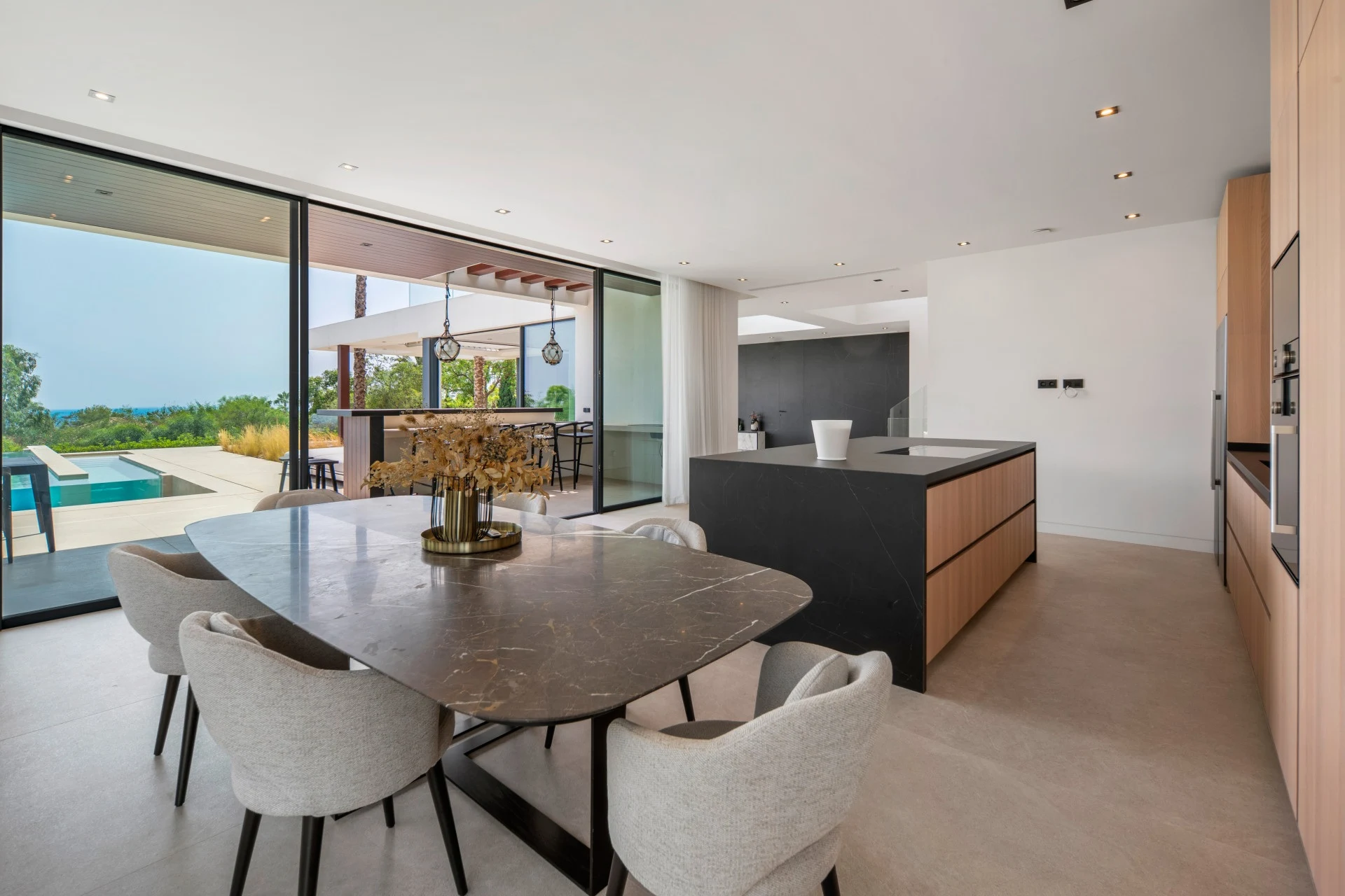 Dining area and open-plan kitchen overlooking the pool