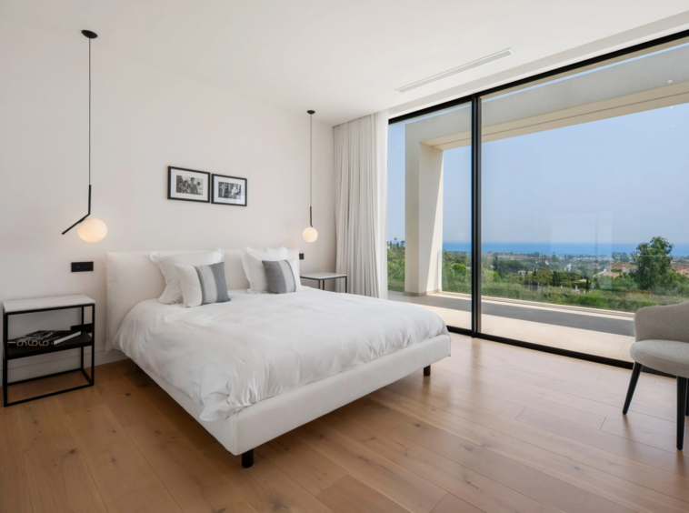 Bedroom with full-height glazing and coastal outlook