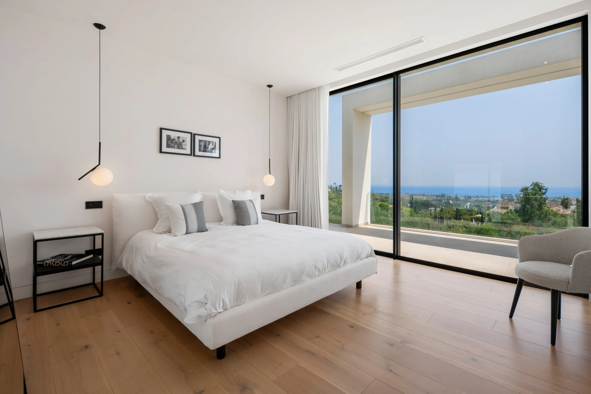 Bedroom with full-height glazing and coastal outlook