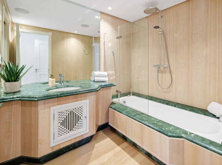 Bathroom with green stone vanity and bathtub