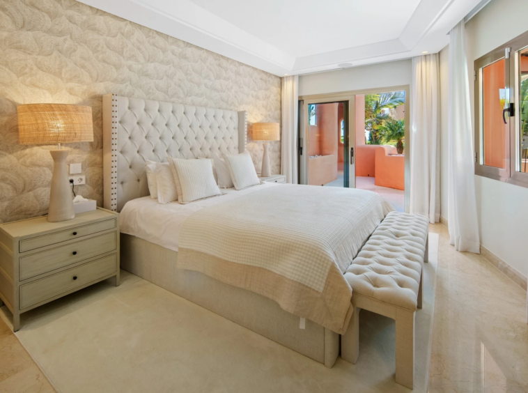 Guest bedroom with upholstered bed and terrace-facing windows