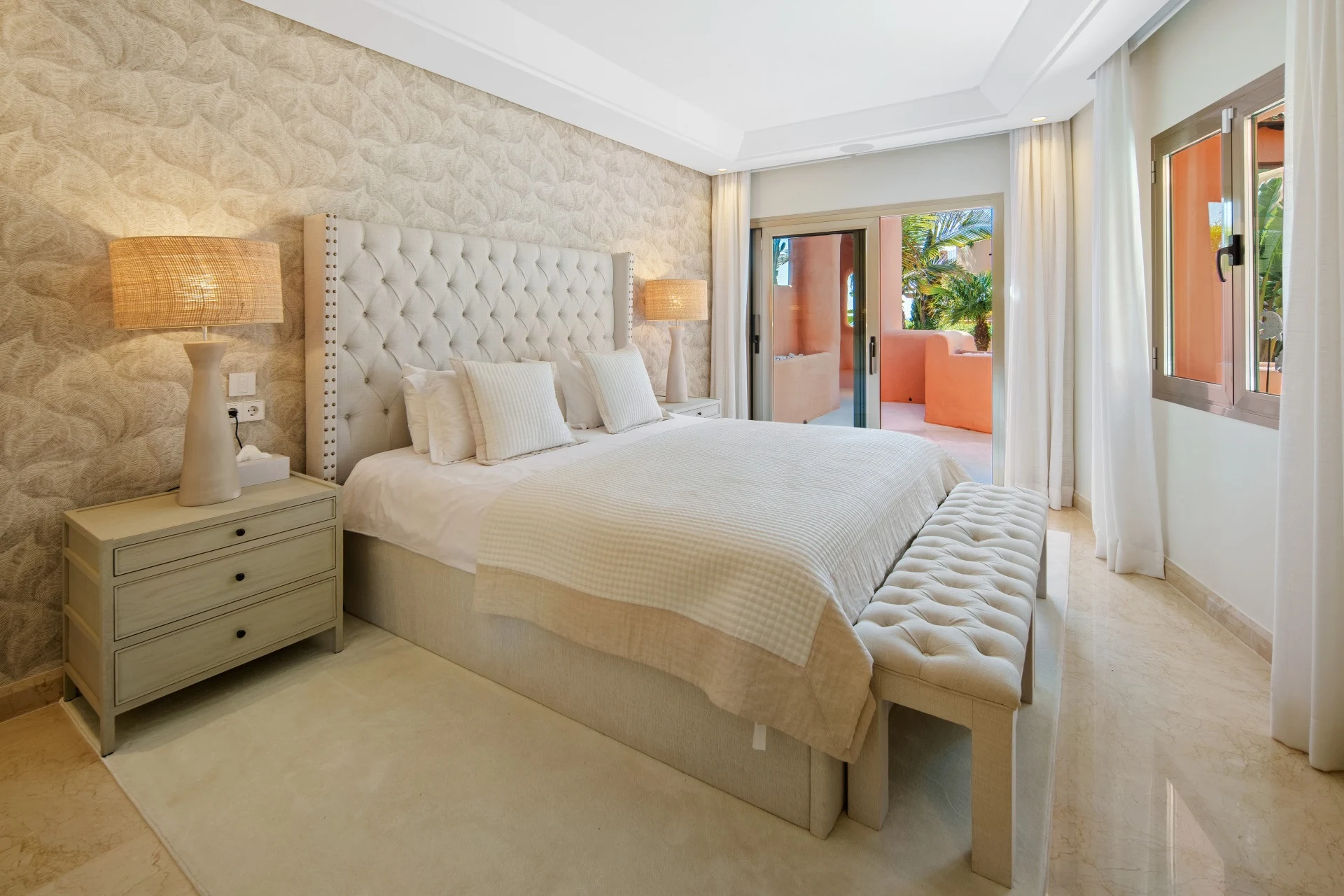 Guest bedroom with upholstered bed and terrace-facing windows