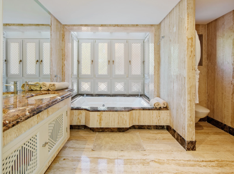 Marble bathroom with bathtub and glazed shower enclosure