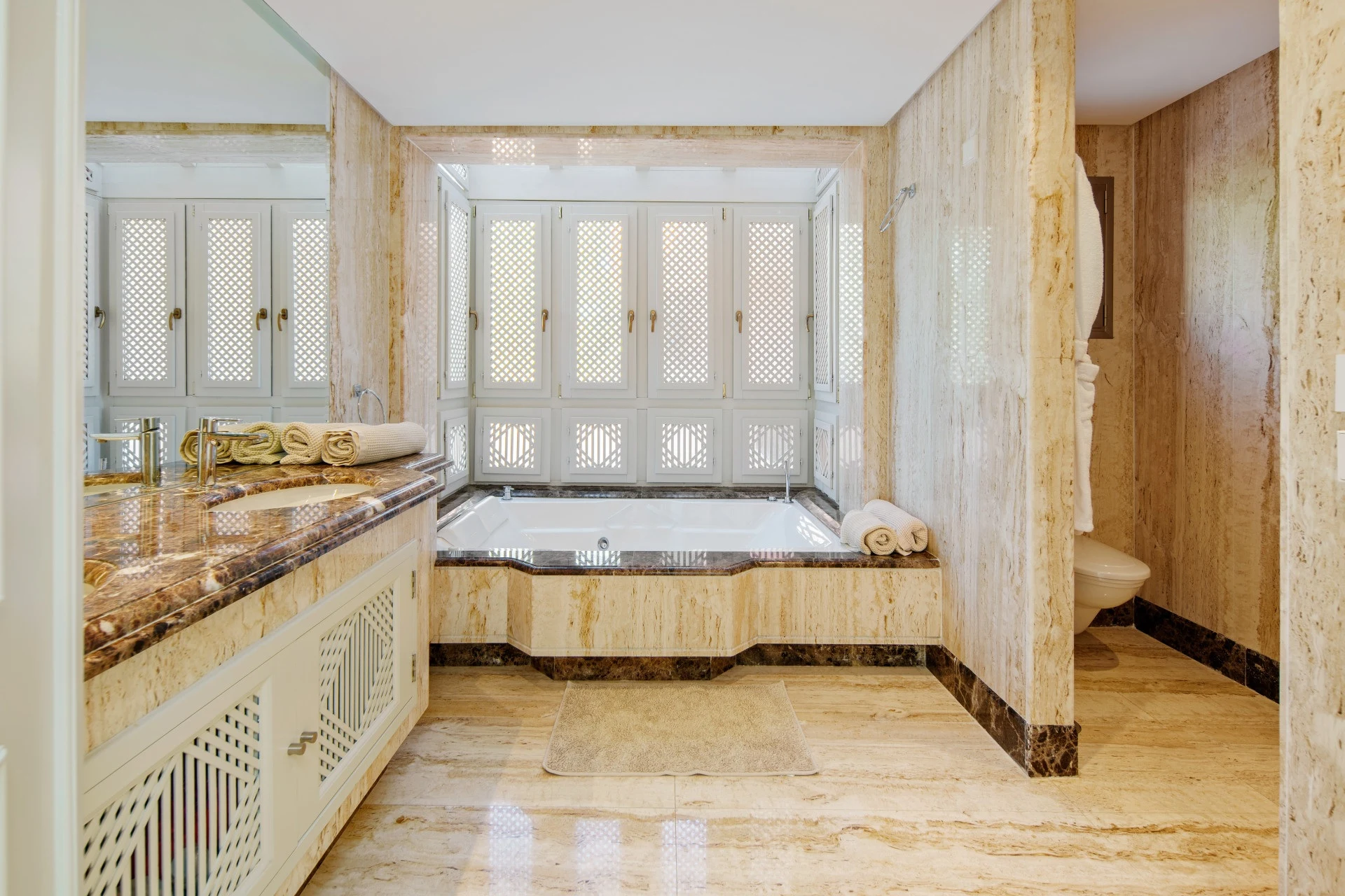 Marble bathroom with bathtub and glazed shower enclosure