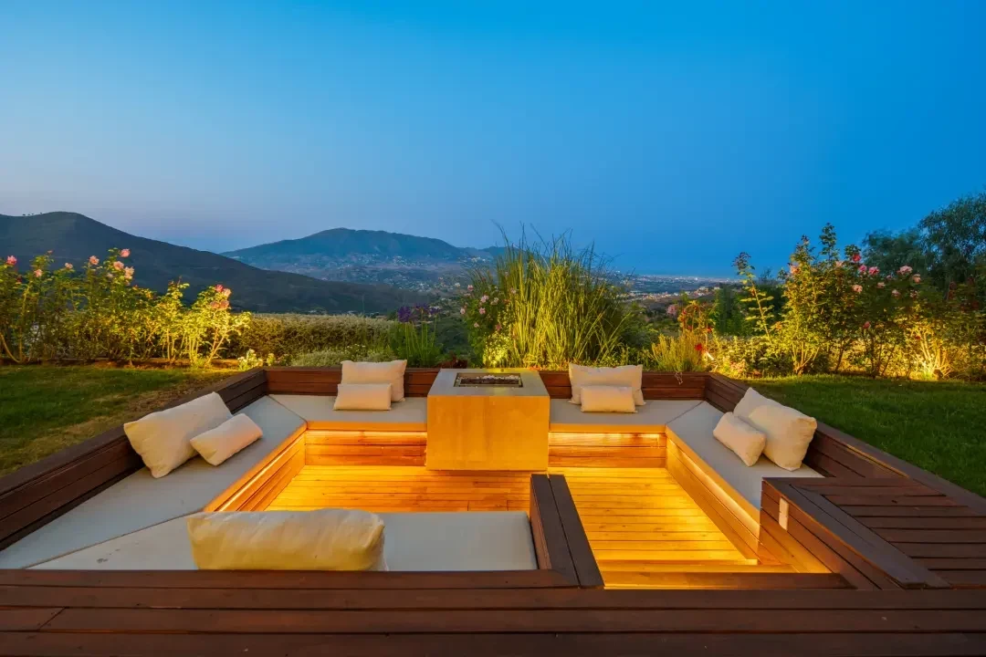 Sunken outdoor fire-pit lounge at dusk in Marbella East