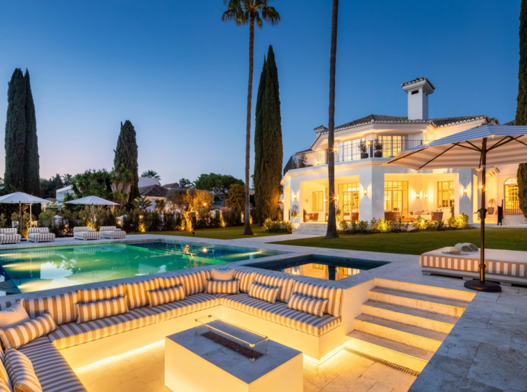 Illuminated sunken lounge and villa beside the pool at dusk