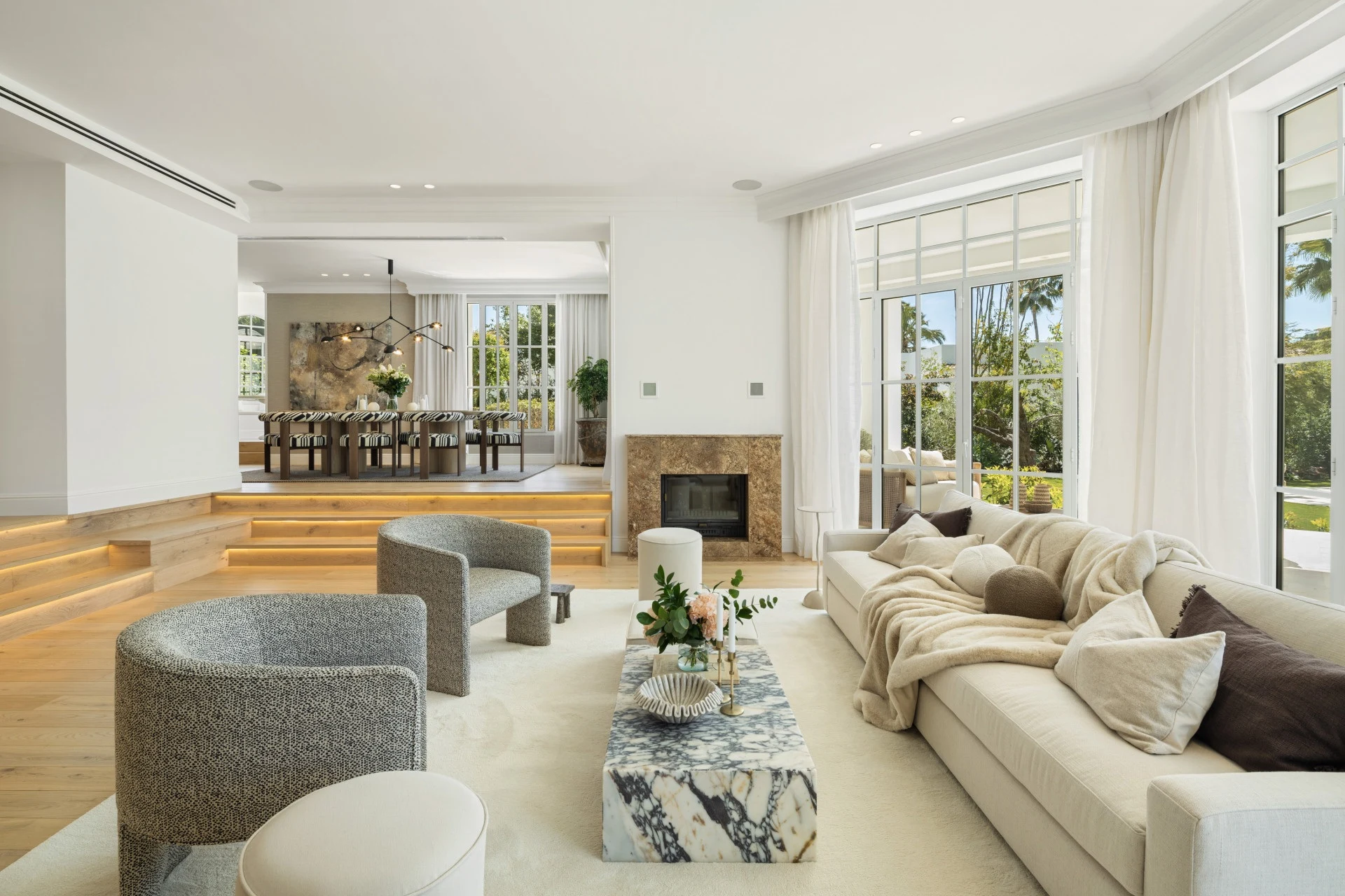 Bright living room with fireplace and garden-facing windows
