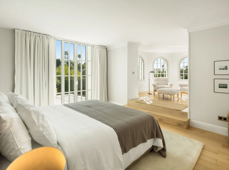 Guest bedroom with garden-facing windows and seating area