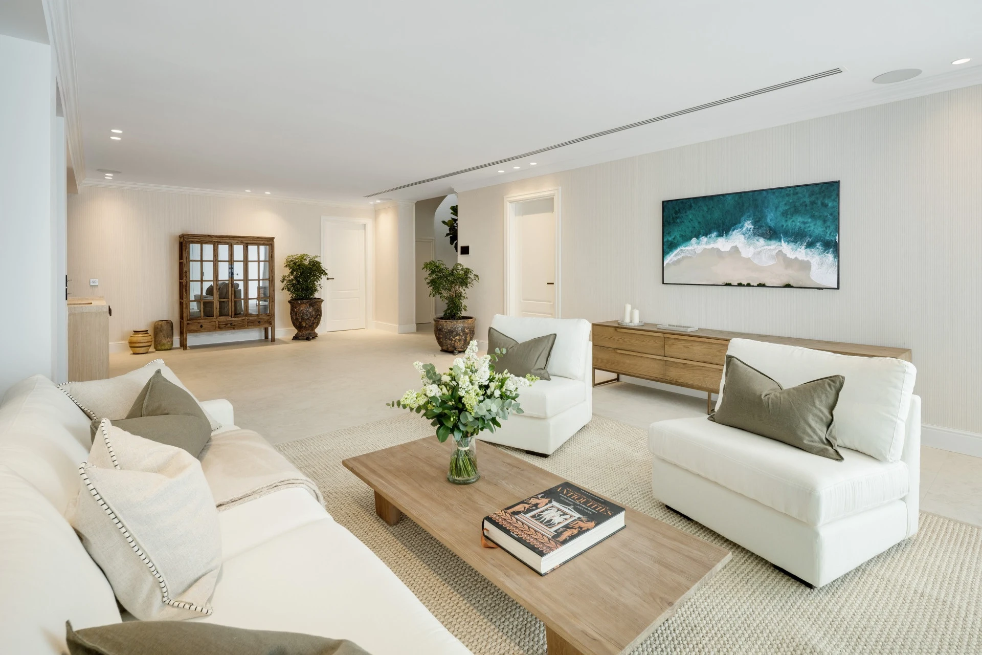 Lower-level lounge with pale sofas and contemporary artwork