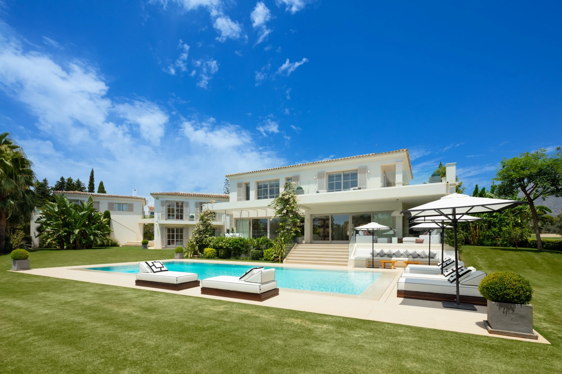 Villa exterior with private swimming pool and landscaped lawn