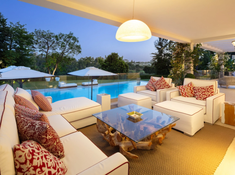Illuminated covered lounge terrace beside the pool
