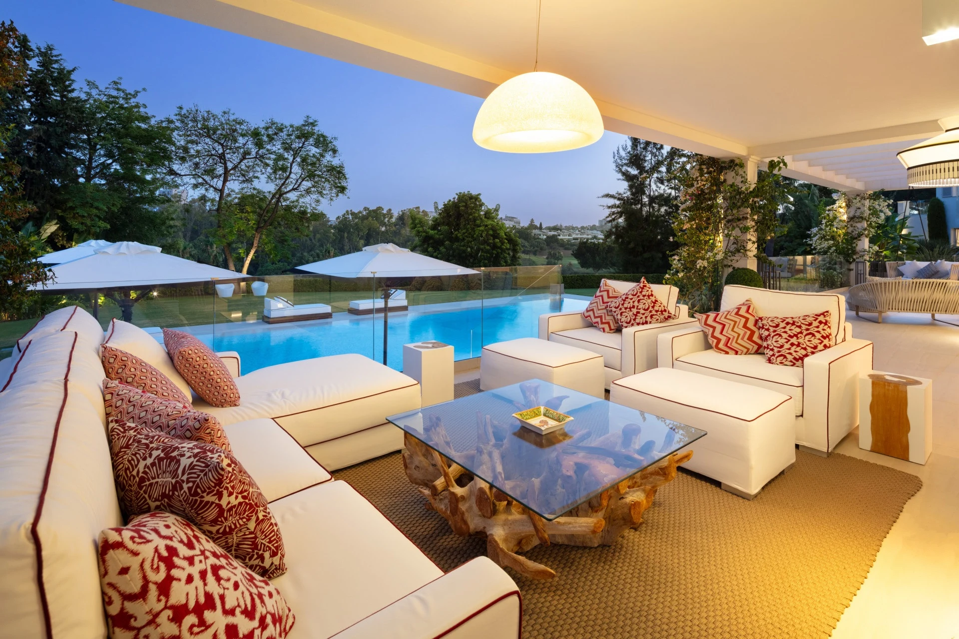 Illuminated covered lounge terrace beside the pool