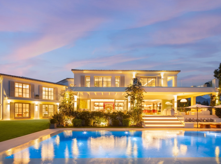 Evening view of the villa and illuminated swimming pool